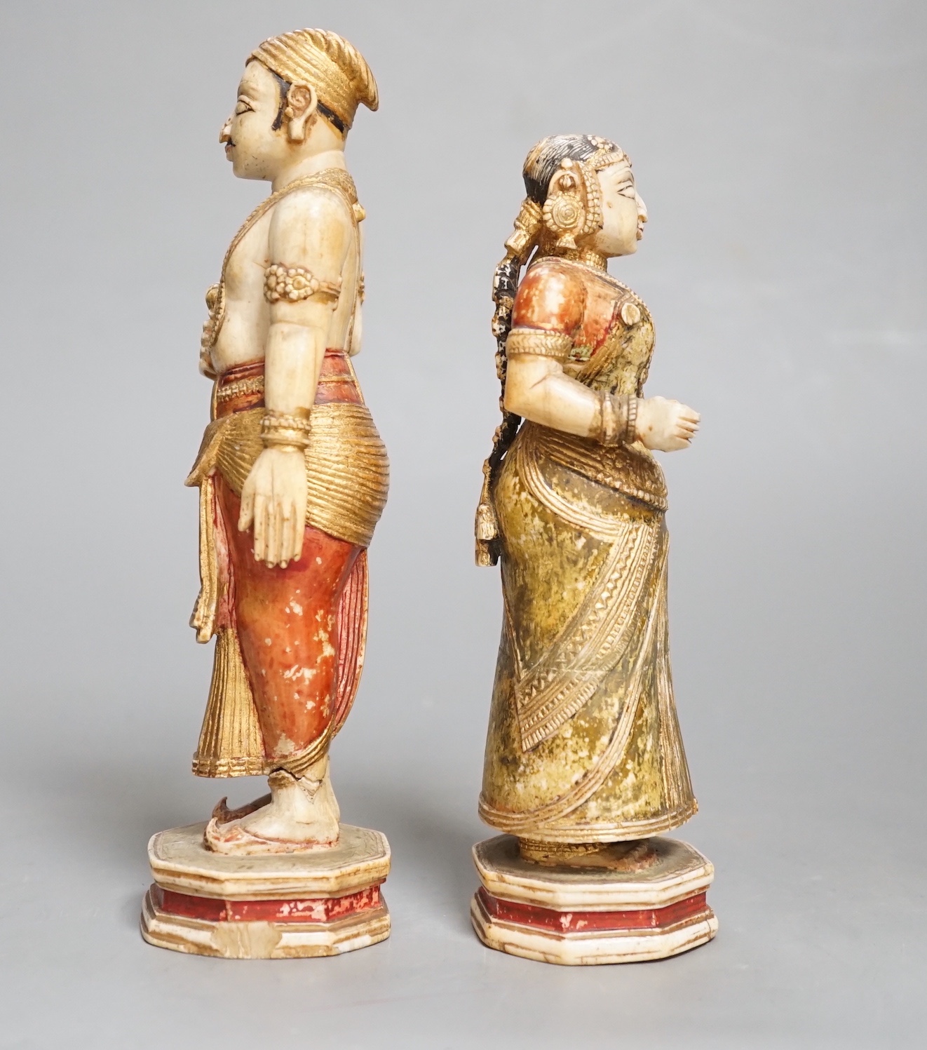 A pair of 18th century painted carved Indian ivory figures, male 7.6cm high female: 5.5cm high